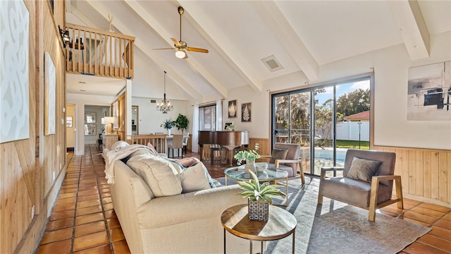 tiled living room featuring beamed ceiling, ceiling fan with notable chandelier, high vaulted ceiling, and wooden walls