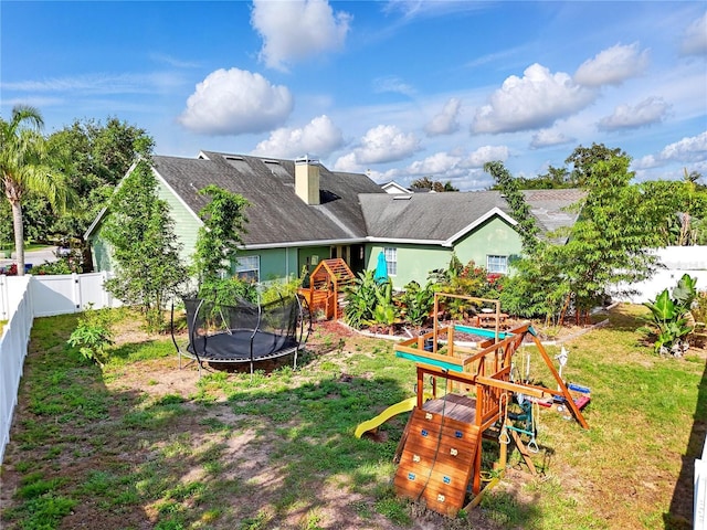 1935 Austin Ter, Winter Haven, FL 33884 - rear view of house featuring a playground, a trampoline, a chimney, a lawn, and a fenced backyard