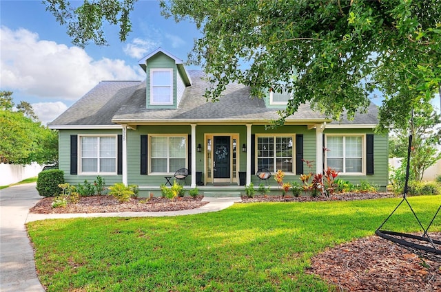 1935 Austin Ter, Winter Haven, FL 33884 - cape cod-style house featuring a front lawn, a shingled roof, and covered porch