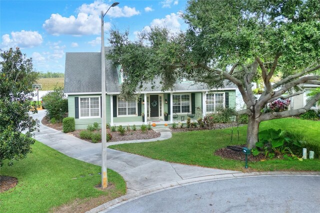 1935 Austin Ter, Winter Haven, FL 33884 - view of front facade with covered porch, roof with shingles, and a front lawn