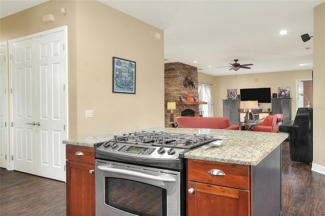 1935 Austin Ter, Winter Haven, FL 33884 - kitchen with stainless steel gas range oven, dark wood-type flooring, ceiling fan, a stone fireplace, and light stone counters