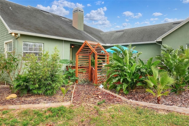 1935 Austin Ter, Winter Haven, FL 33884 - rear view of house with a shingled roof, stucco siding, and a chimney