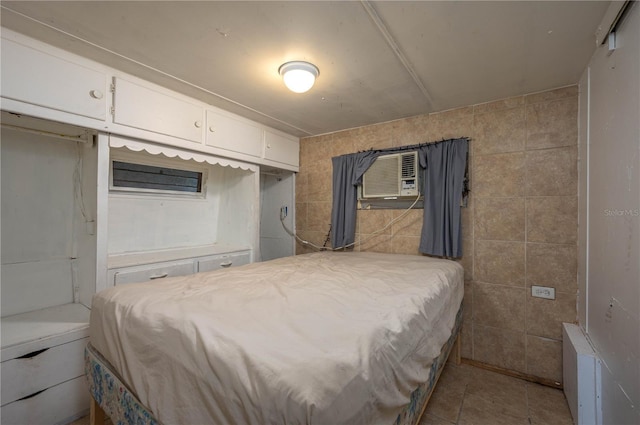 bedroom with a wall mounted AC and light tile patterned floors