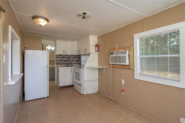 kitchen with tasteful backsplash, an AC wall unit, white cabinets, and white appliances