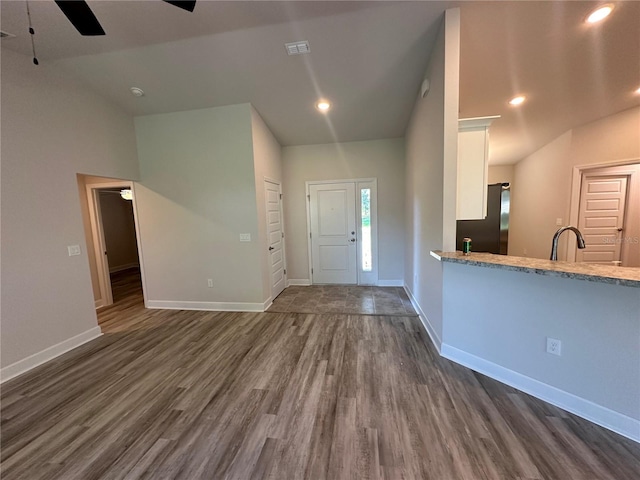 entrance foyer featuring ceiling fan, sink, dark wood-type flooring, and lofted ceiling