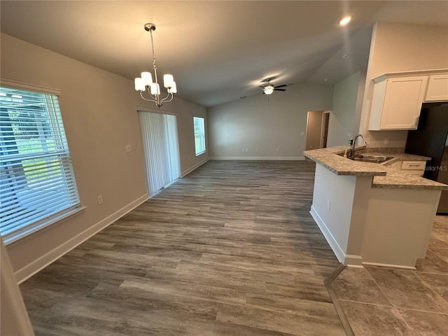 kitchen featuring plenty of natural light, kitchen peninsula, sink, and vaulted ceiling