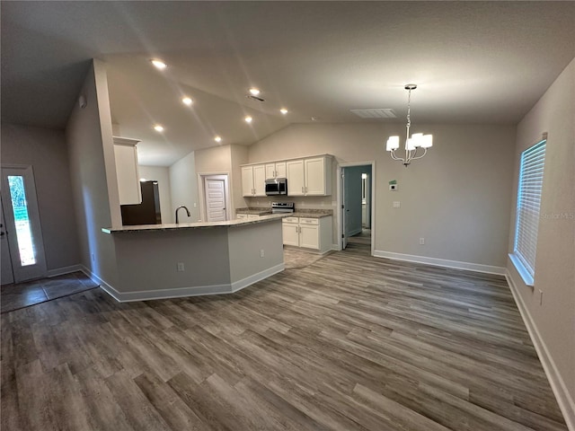 kitchen featuring light stone countertops, dark wood-type flooring, stainless steel appliances, vaulted ceiling, and white cabinets