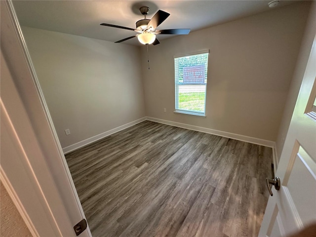 spare room featuring dark hardwood / wood-style floors and ceiling fan