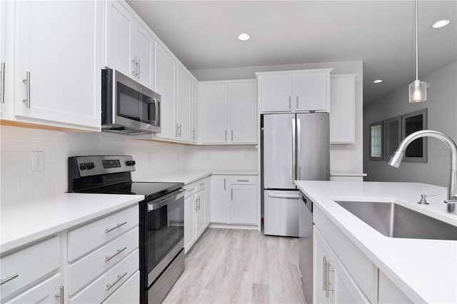 kitchen featuring light hardwood / wood-style floors, white cabinetry, sink, and appliances with stainless steel finishes