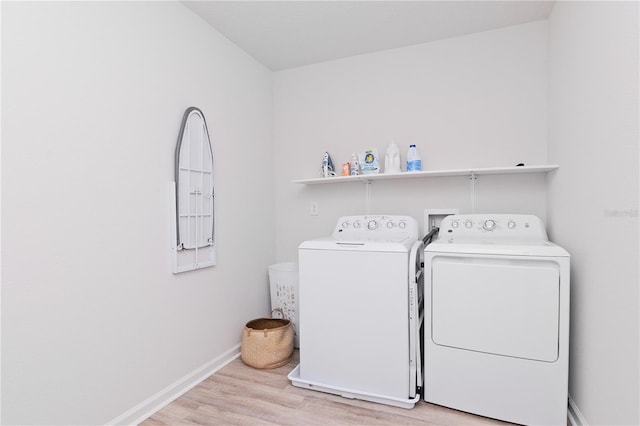 laundry area featuring washer and clothes dryer and light hardwood / wood-style floors