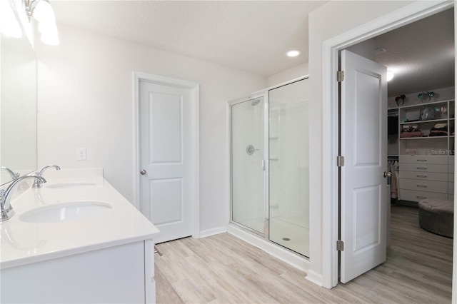 bathroom featuring vanity, an enclosed shower, and wood-type flooring