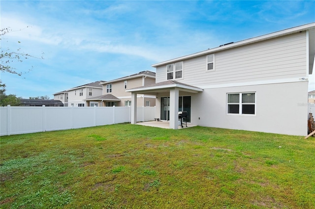 back of house with a patio and a yard