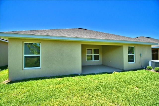 back of house with central air condition unit, a lawn, and a patio area