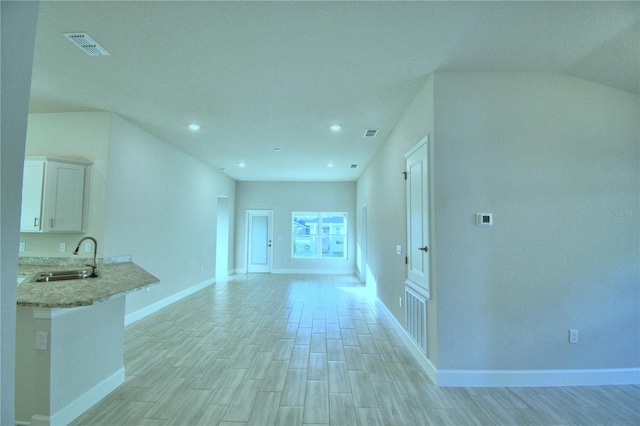 unfurnished living room with light wood-type flooring and sink