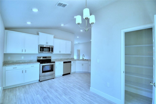 kitchen featuring white cabinetry, appliances with stainless steel finishes, vaulted ceiling, and hanging light fixtures