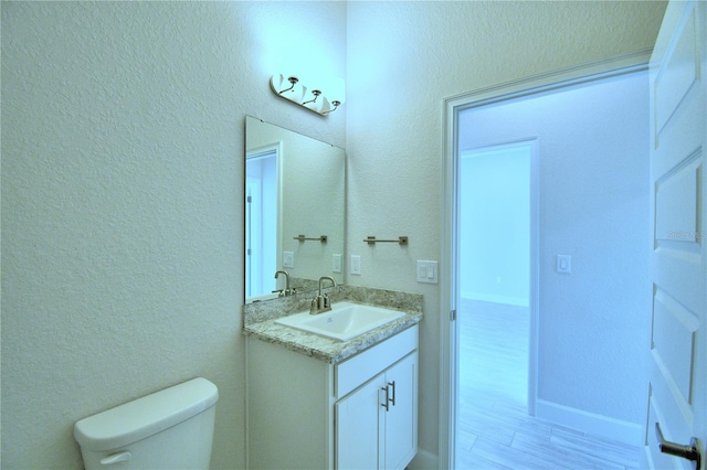 bathroom featuring hardwood / wood-style floors, vanity, and toilet