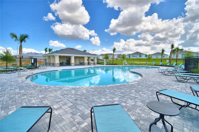 view of swimming pool with a lawn, an outdoor structure, and a patio