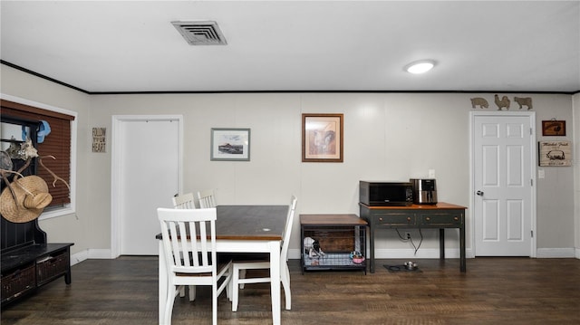 dining area featuring ornamental molding and dark hardwood / wood-style floors