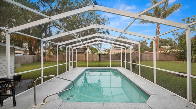 view of swimming pool featuring glass enclosure and a yard