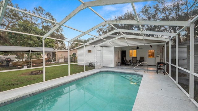 view of swimming pool featuring ceiling fan, a lanai, a yard, and a patio