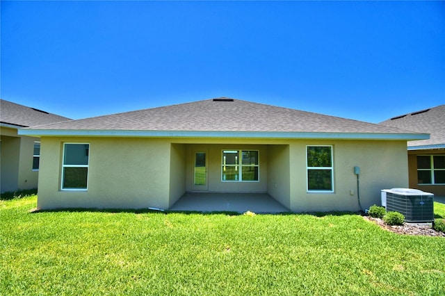 rear view of property with central AC unit, a lawn, and a patio area