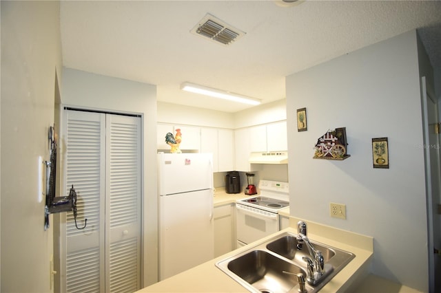 kitchen with white appliances, white cabinetry, and sink