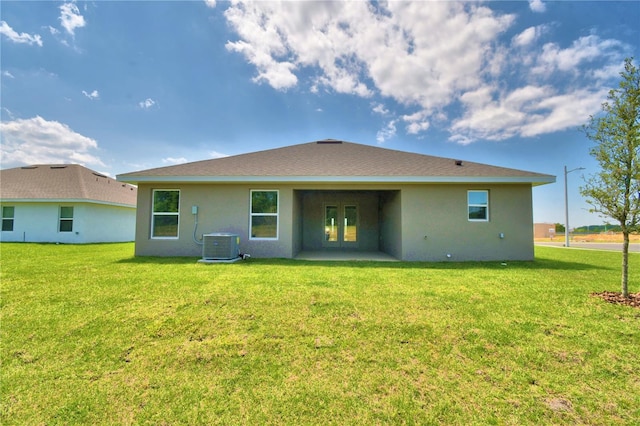 back of property with central AC unit, a patio, and a yard