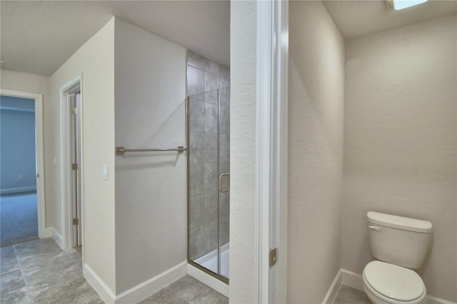 bathroom featuring toilet and a shower with shower door