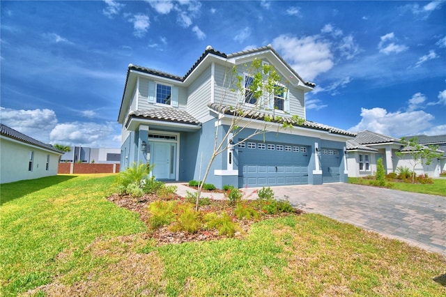 view of front of property with a front yard, a tile roof, a garage, and decorative driveway