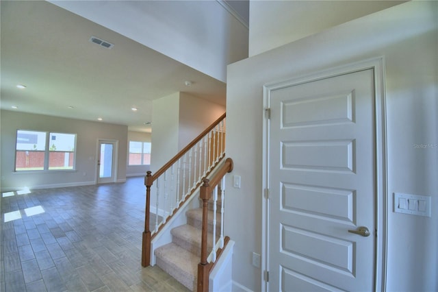 stairs featuring visible vents, baseboards, recessed lighting, and wood finished floors