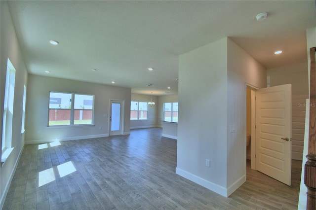 interior space with baseboards, recessed lighting, and wood finished floors