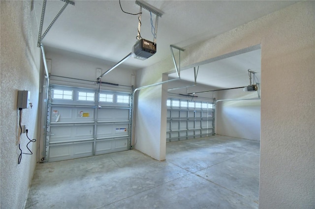 garage with a textured wall and a garage door opener