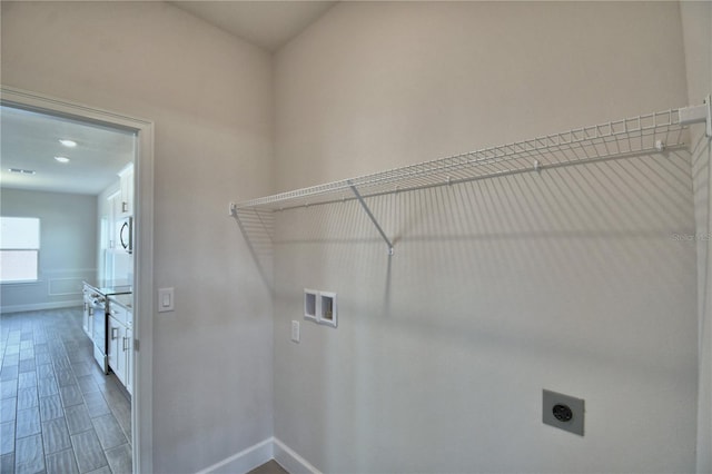 washroom with hookup for an electric dryer, baseboards, washer hookup, laundry area, and wood finished floors