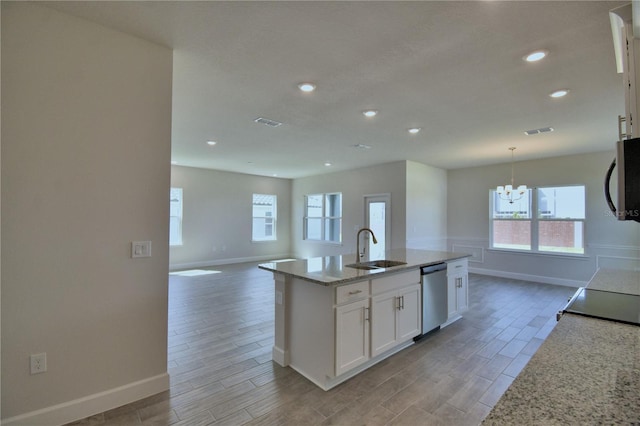 kitchen with white cabinets, dishwasher, a sink, open floor plan, and wood tiled floor