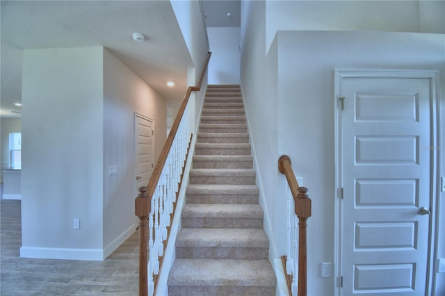 stairway with wood finished floors and baseboards