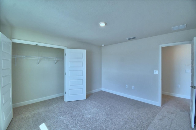 unfurnished bedroom with baseboards, carpet, and visible vents