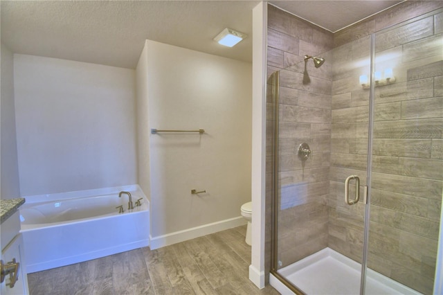 bathroom featuring baseboards, a bath, toilet, wood finished floors, and a stall shower