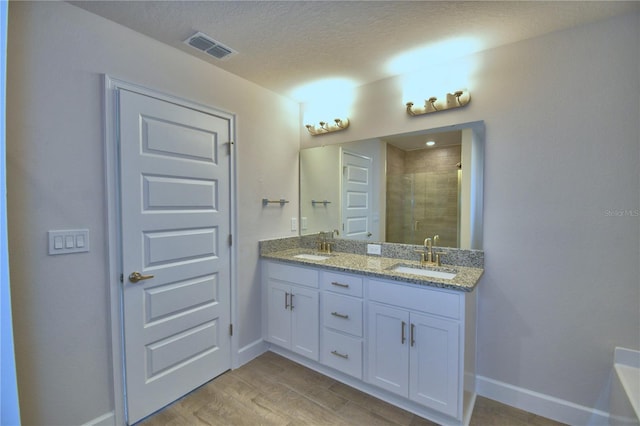 full bath featuring double vanity, visible vents, a sink, and a stall shower
