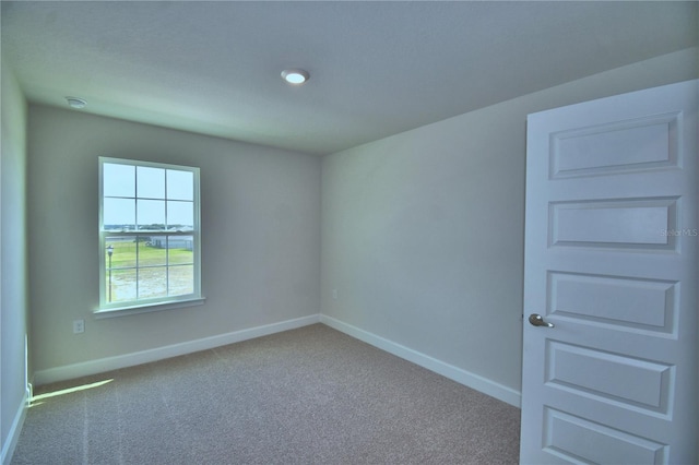 carpeted empty room with baseboards
