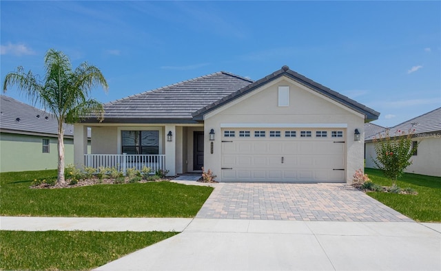 ranch-style house featuring covered porch, a garage, and a front yard