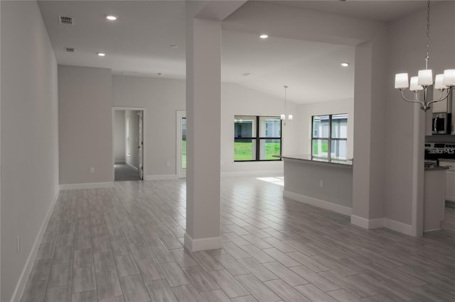 interior space featuring a chandelier, light wood-type flooring, and lofted ceiling