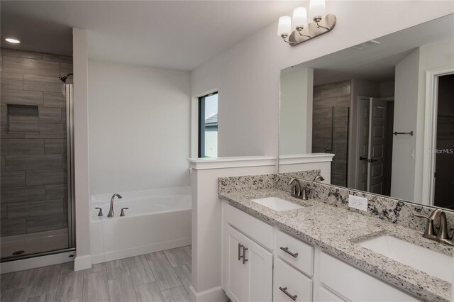 bathroom featuring vanity, hardwood / wood-style flooring, and plus walk in shower