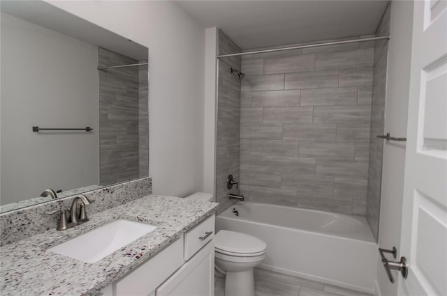 full bathroom with vanity, wood-type flooring, tiled shower / bath, and toilet