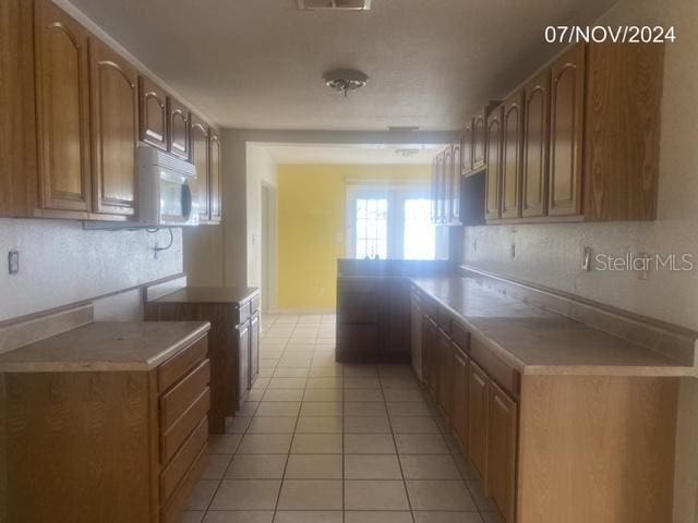 kitchen with kitchen peninsula and light tile patterned flooring