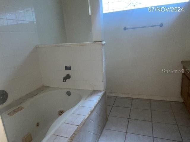 bathroom featuring tile patterned floors, a washtub, and vanity