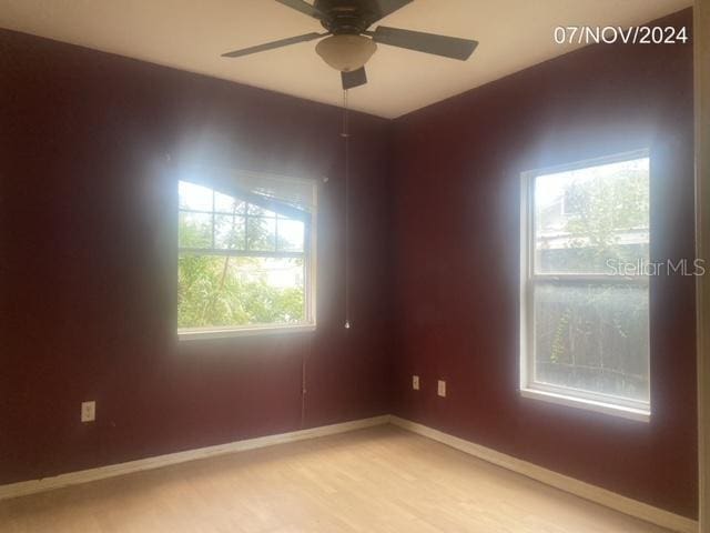 unfurnished room with ceiling fan, plenty of natural light, and light hardwood / wood-style flooring