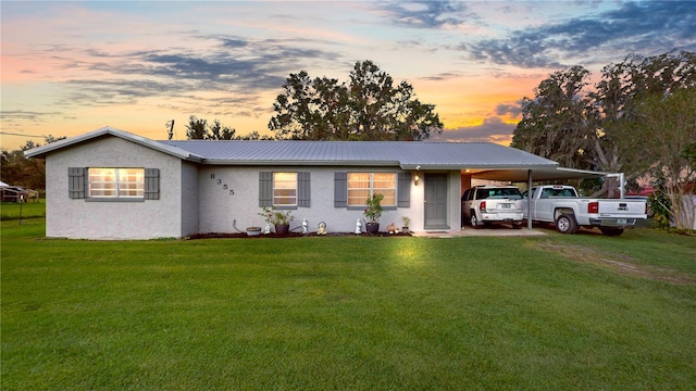 ranch-style house with a yard and a carport