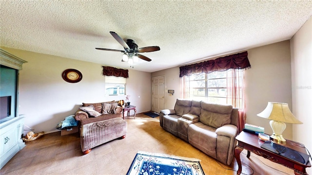 living room with a textured ceiling, light carpet, and ceiling fan