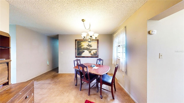 dining area with light hardwood / wood-style floors, a textured ceiling, and an inviting chandelier