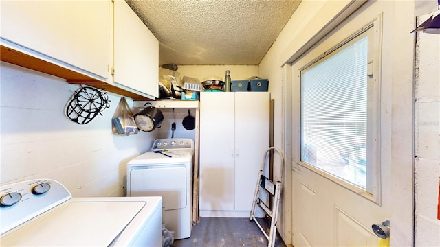 laundry area with a textured ceiling, dark wood-type flooring, cabinets, and independent washer and dryer